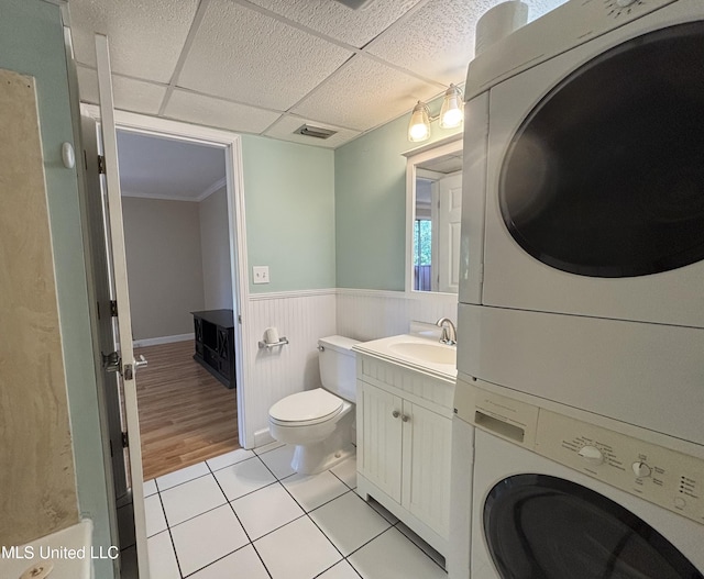 248 Lakeside Villa Unit J, Diamondhead, MS 39525 - bathroom with vanity, stacked washer and clothes dryer, tile patterned floors, toilet, and a wainscoted wall