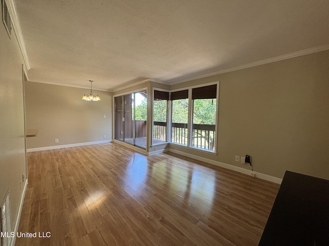 248 Lakeside Villa Unit J, Diamondhead, MS 39525 - empty room with wood finished floors, a notable chandelier, a textured ceiling, and crown molding