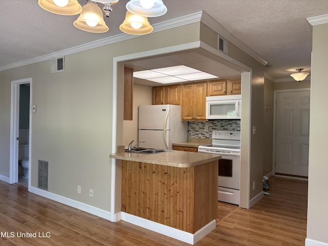 248 Lakeside Villa Unit J, Diamondhead, MS 39525 - kitchen featuring light wood finished floors, a sink, visible vents, backsplash, and white appliances