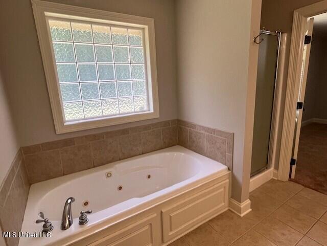 104 Blackstone Cir, Brandon, MS 39047 - full bathroom featuring healthy amount of natural light, a shower stall, a jetted tub, and tile patterned floors