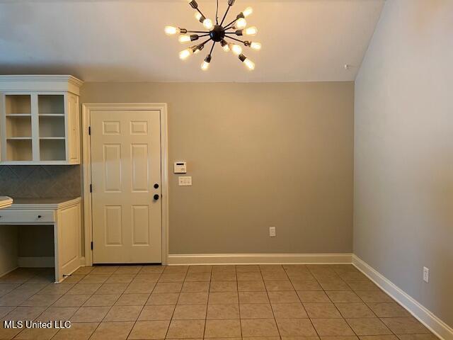 104 Blackstone Cir, Brandon, MS 39047 - unfurnished dining area with a chandelier and light tile patterned flooring