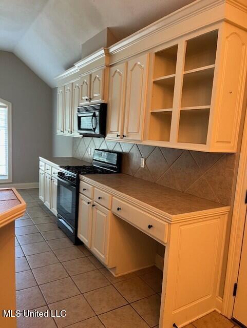 104 Blackstone Cir, Brandon, MS 39047 - kitchen featuring black appliances, tile counters, light tile patterned floors, vaulted ceiling, and tasteful backsplash