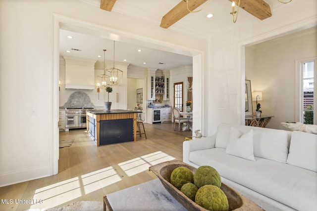 living room featuring beam ceiling, light hardwood / wood-style flooring, and a wealth of natural light