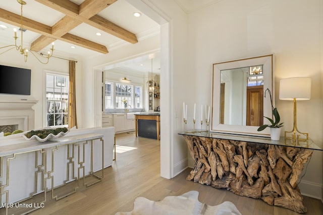 interior space with an inviting chandelier, beam ceiling, coffered ceiling, ornamental molding, and light wood-type flooring