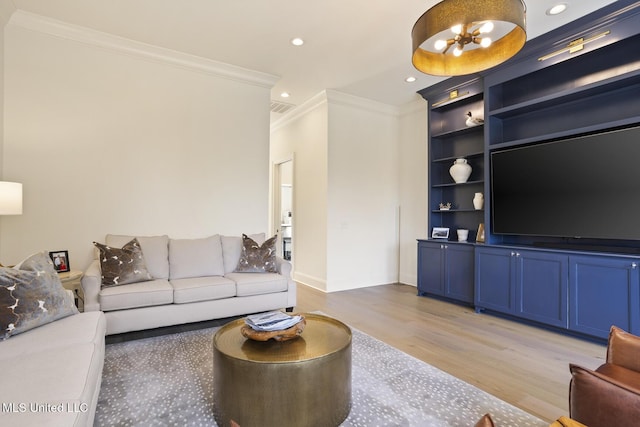 living room with built in shelves, light hardwood / wood-style flooring, and ornamental molding