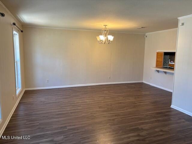 interior space with baseboards, dark wood-style flooring, an inviting chandelier, and crown molding