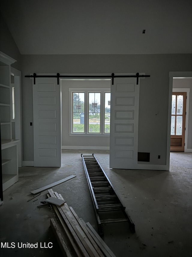 empty room with a barn door and baseboards