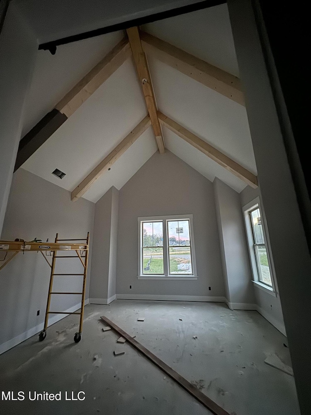 interior space featuring beam ceiling, baseboards, and high vaulted ceiling