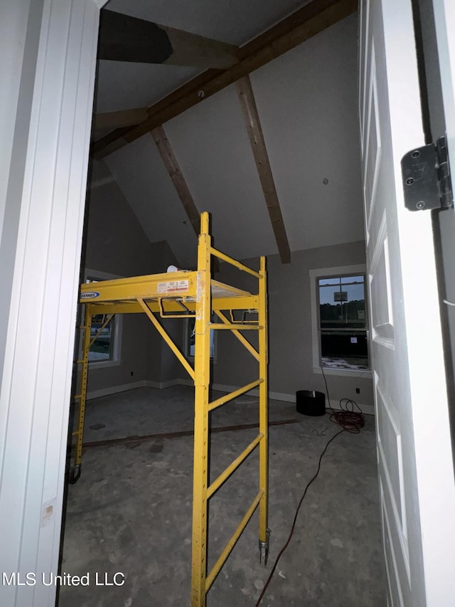 unfurnished bedroom featuring vaulted ceiling and concrete floors