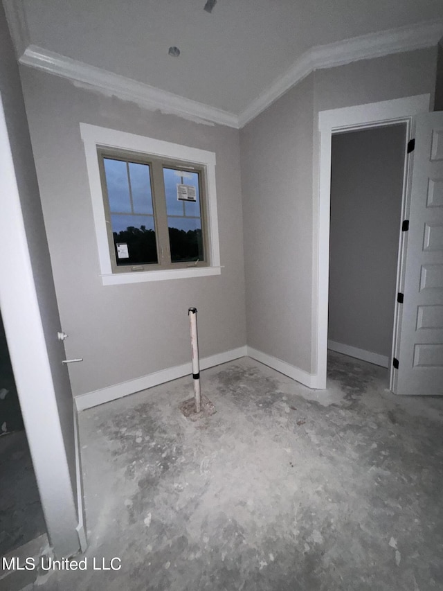 unfurnished room with unfinished concrete floors, baseboards, and ornamental molding