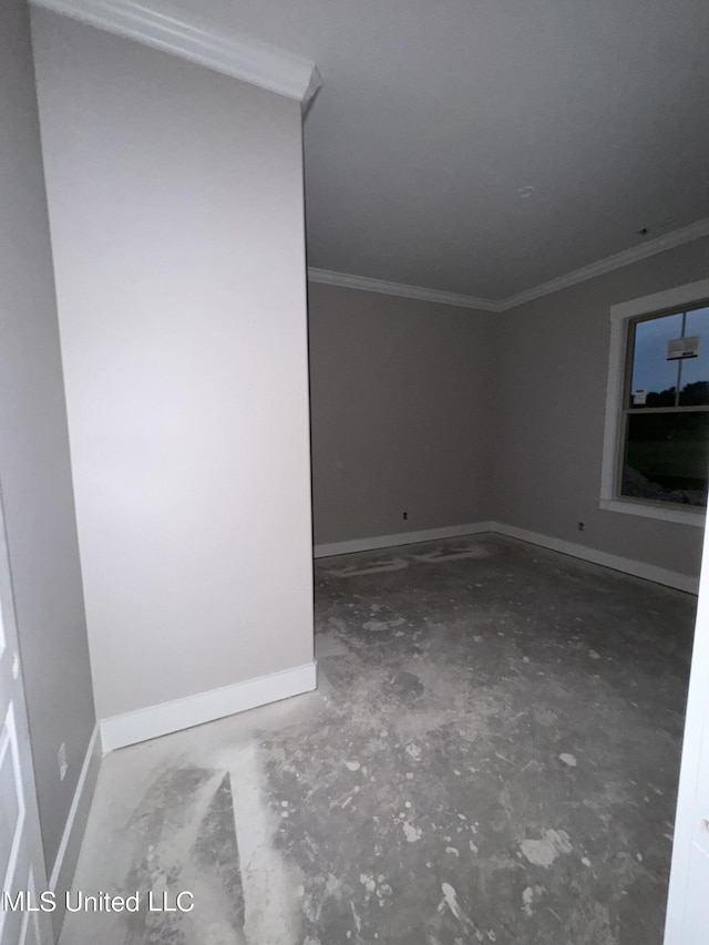 empty room featuring baseboards, unfinished concrete flooring, and crown molding