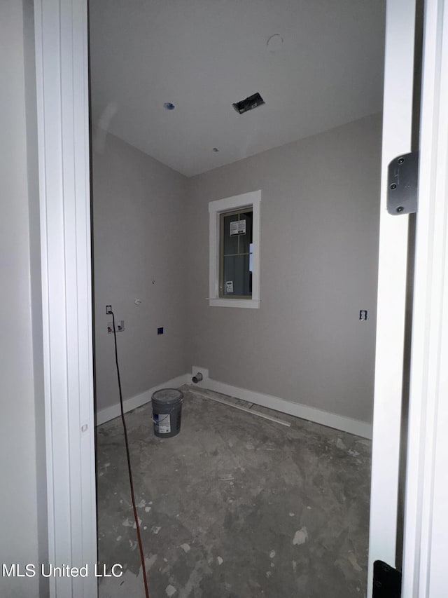 clothes washing area featuring baseboards