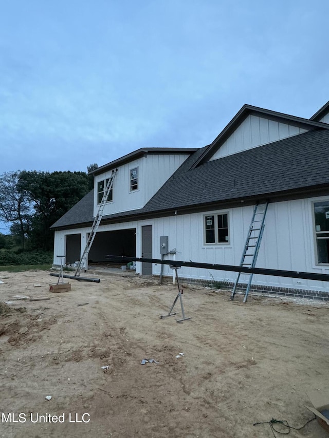 view of side of home with a shingled roof