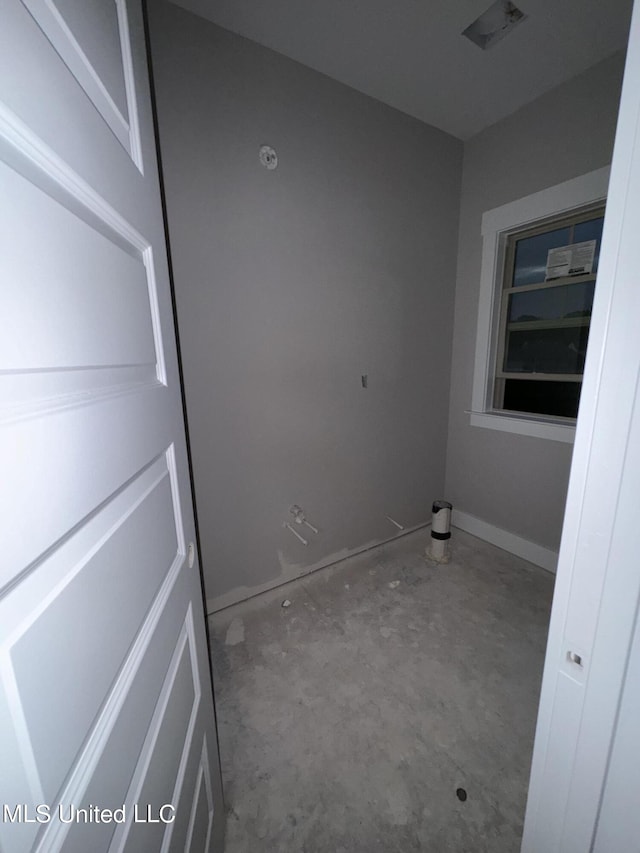 unfurnished room with unfinished concrete floors and baseboards