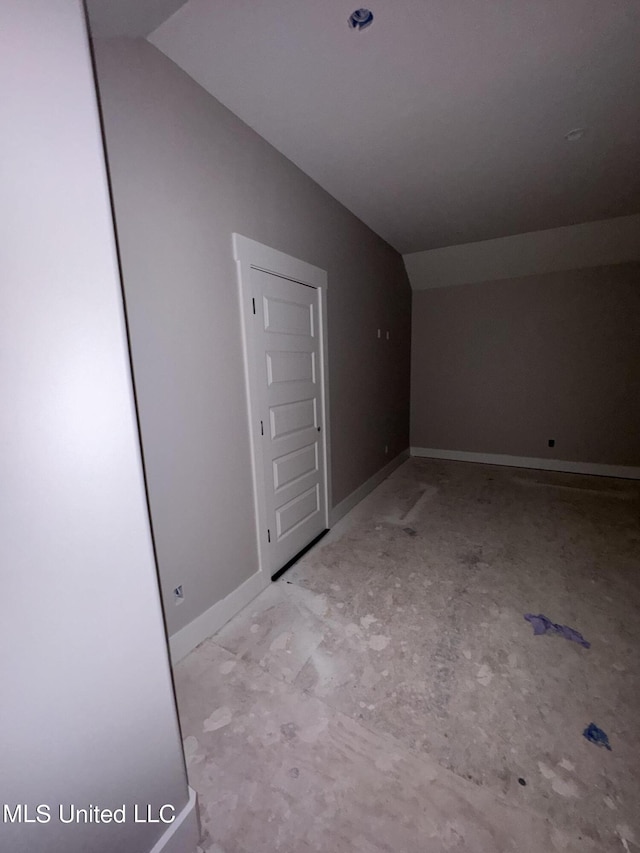 additional living space featuring baseboards and lofted ceiling