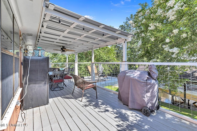 wooden deck with area for grilling and ceiling fan