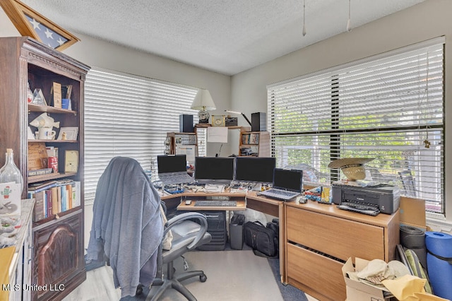 carpeted home office with a textured ceiling