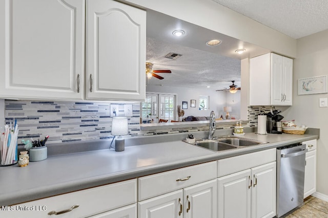 kitchen featuring stainless steel dishwasher, sink, white cabinets, and a textured ceiling