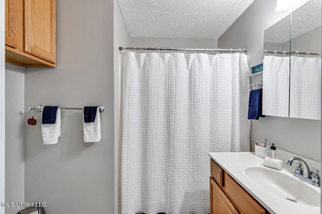 bathroom featuring vanity, a textured ceiling, and a shower with shower curtain