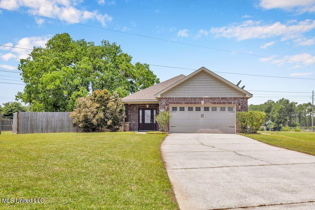 1017 Pelican Cv, Ocean Springs, MS 39564 - view of front of home featuring brick siding, a garage, and concrete driveway