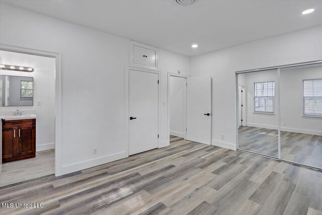 4560 Meadowridge Dr, Jackson, MS 39206 - unfurnished bedroom with a closet, light wood finished floors, multiple windows, and baseboards