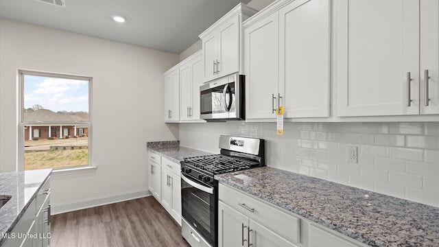 kitchen featuring appliances with stainless steel finishes, dark hardwood / wood-style floors, tasteful backsplash, white cabinetry, and light stone countertops