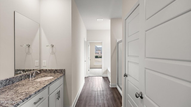 bathroom featuring vanity, hardwood / wood-style floors, and a bathtub