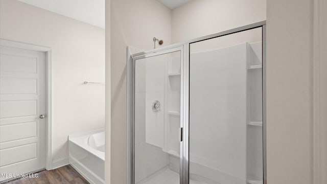 bathroom with independent shower and bath and hardwood / wood-style flooring