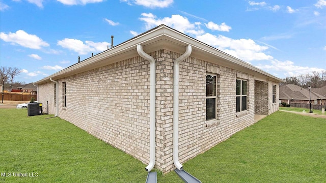 view of side of property featuring a yard and central air condition unit