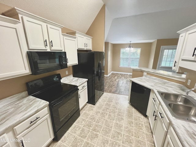 kitchen featuring black appliances, a sink, a chandelier, white cabinetry, and lofted ceiling