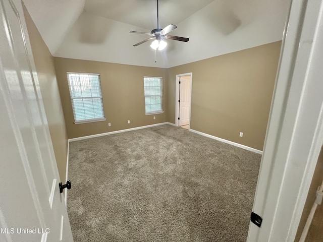 carpeted spare room featuring ceiling fan, baseboards, and lofted ceiling