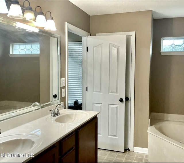 bathroom featuring a garden tub, double vanity, healthy amount of natural light, and tile patterned floors