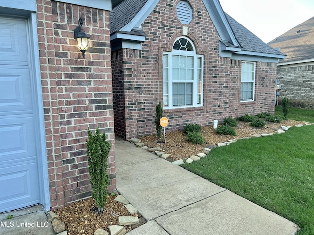 entrance to property with brick siding and roof with shingles