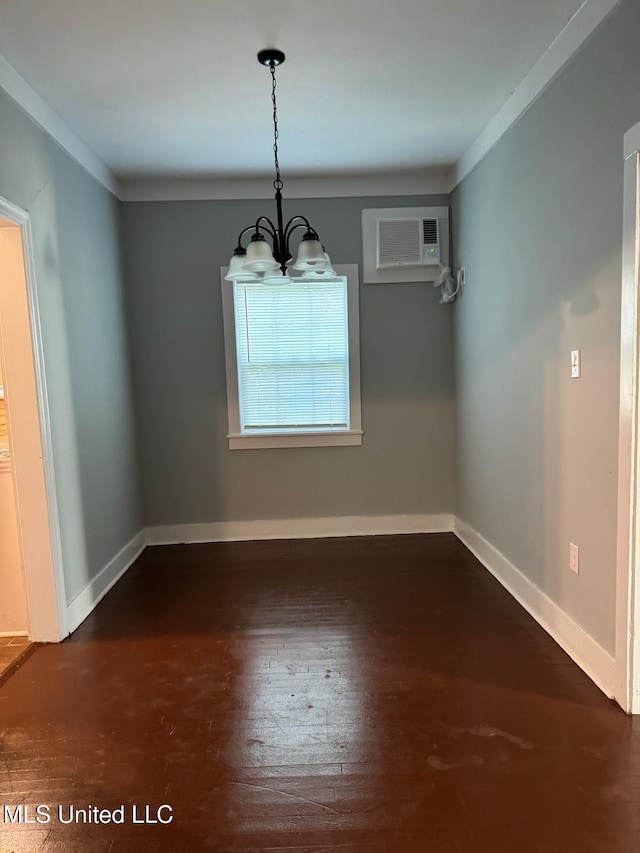 unfurnished dining area featuring a notable chandelier, dark wood-type flooring, ornamental molding, and a wall unit AC