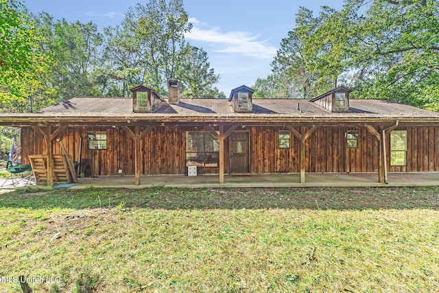 rear view of property featuring a lawn