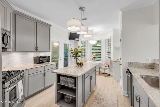 2252 Beach Dr Unit 206, Gulfport, MS 39507 - kitchen featuring appliances with stainless steel finishes, gray cabinets, open shelves, light wood-style floors, and tasteful backsplash