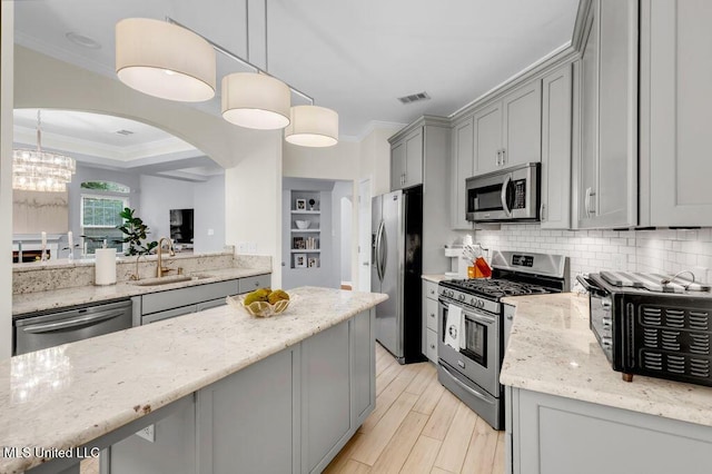 2252 Beach Dr Unit 206, Gulfport, MS 39507 - kitchen featuring stainless steel appliances, gray cabinets, ornamental molding, a chandelier, and arched walkways
