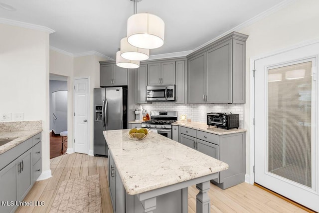 2252 Beach Dr Unit 206, Gulfport, MS 39507 - kitchen featuring stainless steel appliances, gray cabinets, light wood-style flooring, crown molding, and light stone counters