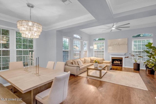 2252 Beach Dr Unit 206, Gulfport, MS 39507 - dining space with wood finished floors, a fireplace, a chandelier, a ceiling fan, and ornamental molding