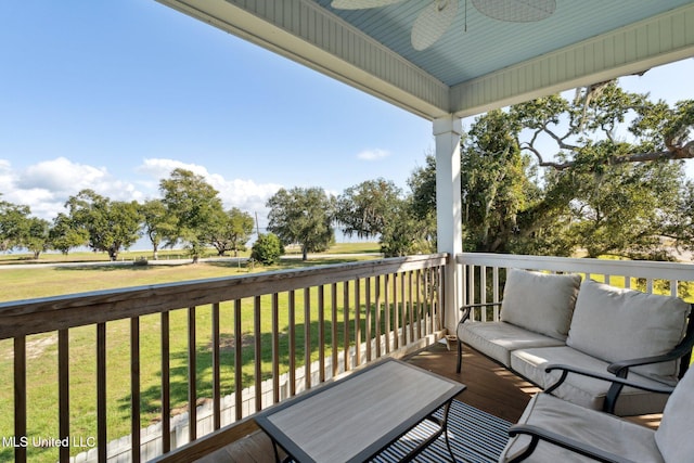 wooden terrace with ceiling fan and a yard