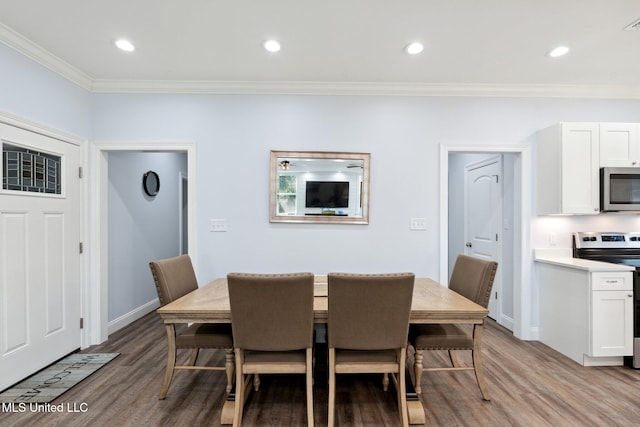 dining area featuring light wood-type flooring and ornamental molding