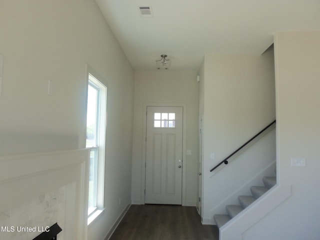 entryway featuring dark wood-type flooring, visible vents, baseboards, and stairs