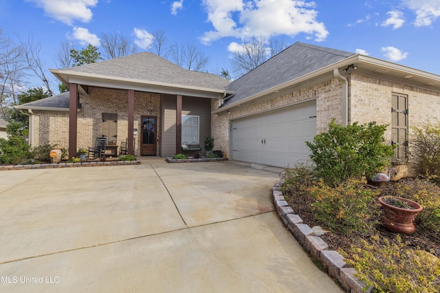 ranch-style home with driveway, a shingled roof, an attached garage, a porch, and brick siding