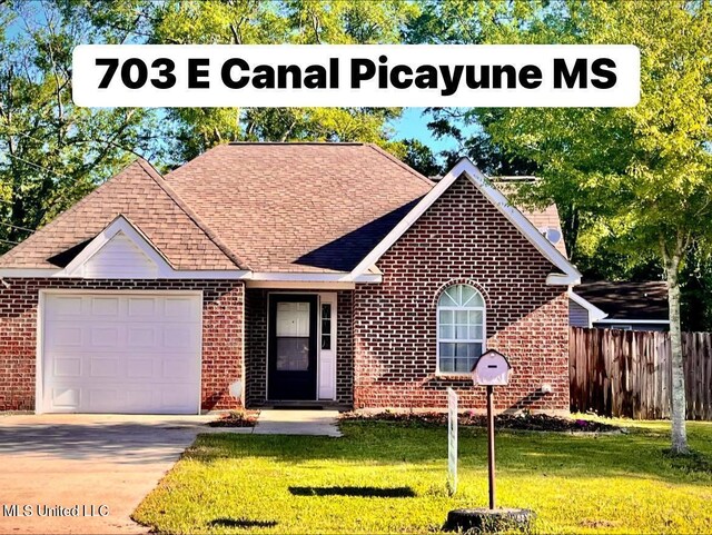 703 E Canal St, Picayune, MS 39466 - view of front of home featuring brick siding, a shingled roof, a garage, and concrete driveway