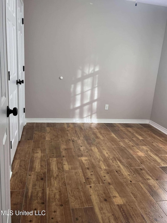 spare room featuring dark wood-type flooring