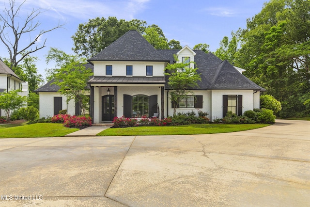 302 Covington Cv, Madison, MS 39110 - french country home featuring a standing seam roof, a front lawn, covered porch, and roof with shingles