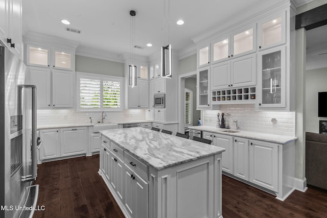 302 Covington Cv, Madison, MS 39110 - kitchen featuring appliances with stainless steel finishes, white cabinetry, dark wood-style floors, a center island, and crown molding