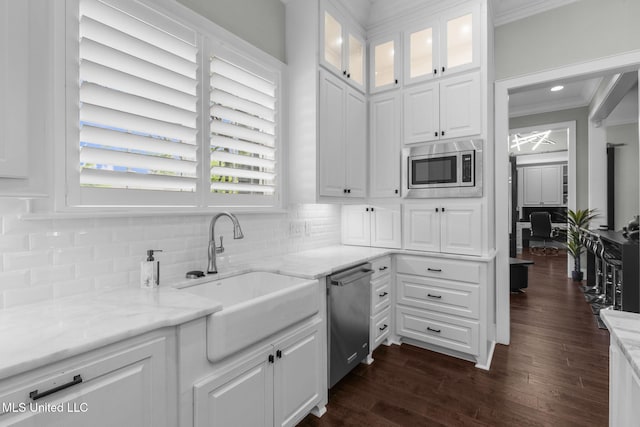 302 Covington Cv, Madison, MS 39110 - kitchen with appliances with stainless steel finishes, crown molding, white cabinetry, light stone countertops, and decorative backsplash