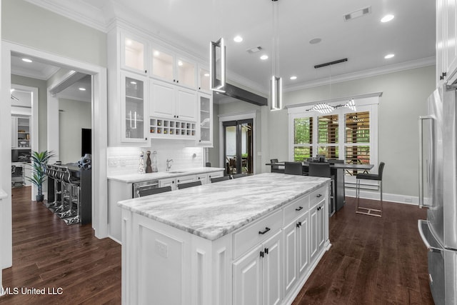 302 Covington Cv, Madison, MS 39110 - kitchen with freestanding refrigerator, ornamental molding, a kitchen island, tasteful backsplash, and hanging light fixtures