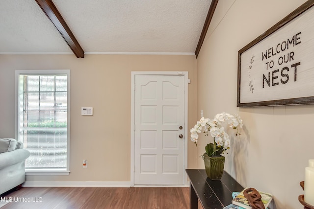 foyer featuring hardwood / wood-style floors, crown molding, beamed ceiling, and a textured ceiling